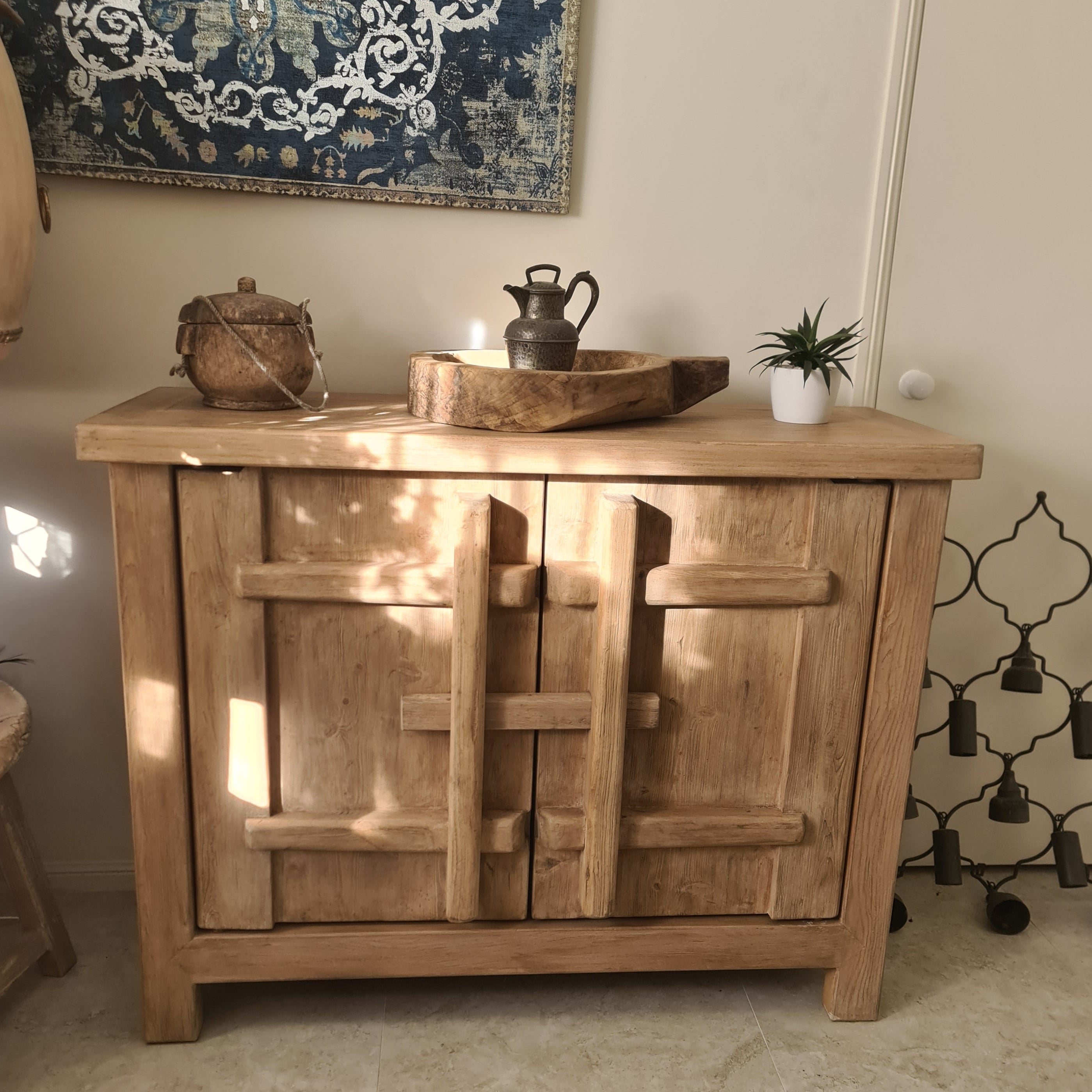 Wooden sideboard in a room with decorative elements on the wall.