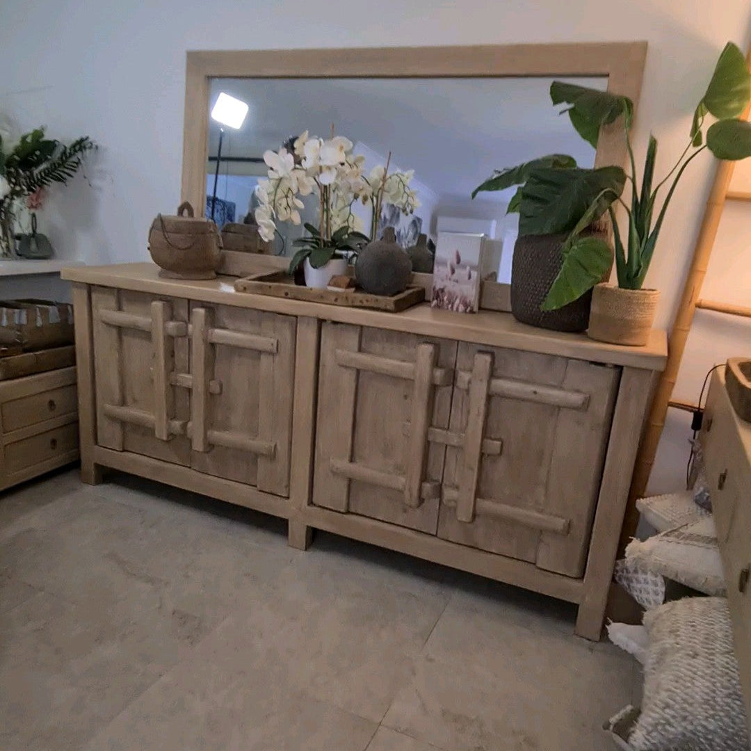 Wooden sideboard with decorative items in a room setting