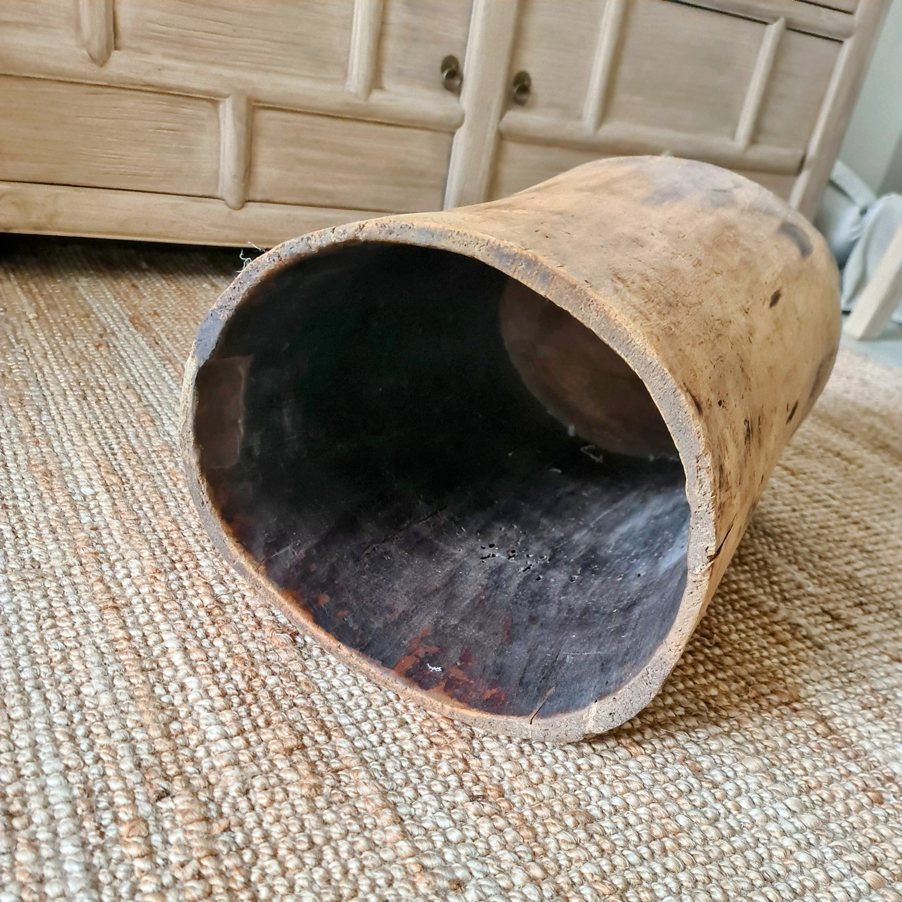 Wooden cylindrical object on a textured surface with a blurred background